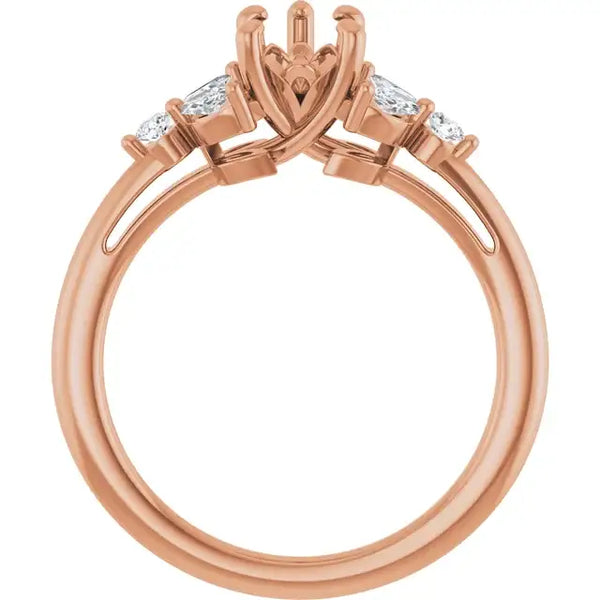 Rose gold engagement ring setting with ornate pear-shaped center stone holder and two smaller diamond accents on each side.