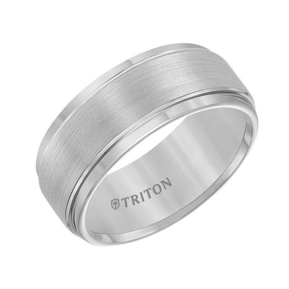 Angled view of a gray tungsten carbide wedding band with brushed center and polished step edges, engraved TRITON inside