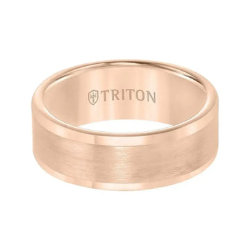 Rose gold-toned satin center wedding band shown on a hand resting on a wooden surface