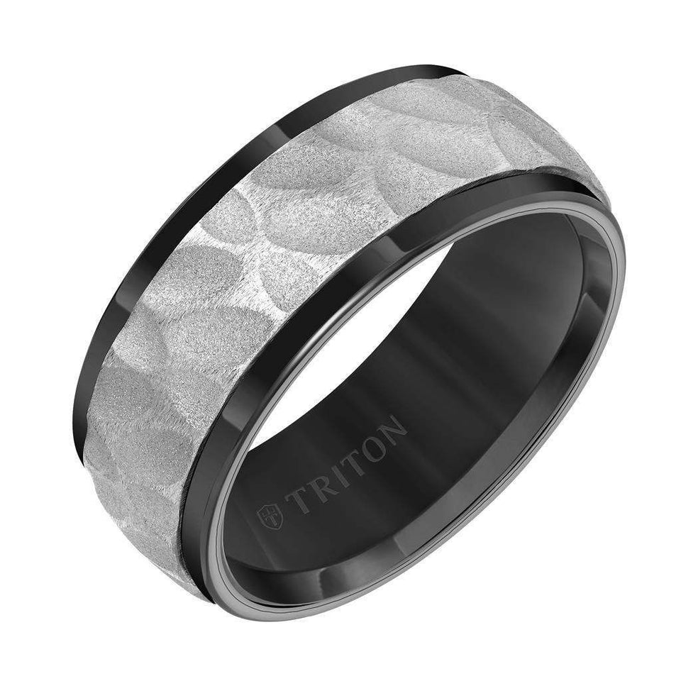 Angle view of a 9mm black tungsten men’s wedding band by Triton featuring a white sandblasted hammered center and polished black beveled edges