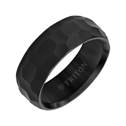 Angled view of an 8mm black tungsten carbide wedding band with hammered edge-to-edge texture and polished interior, engraved with TRITON