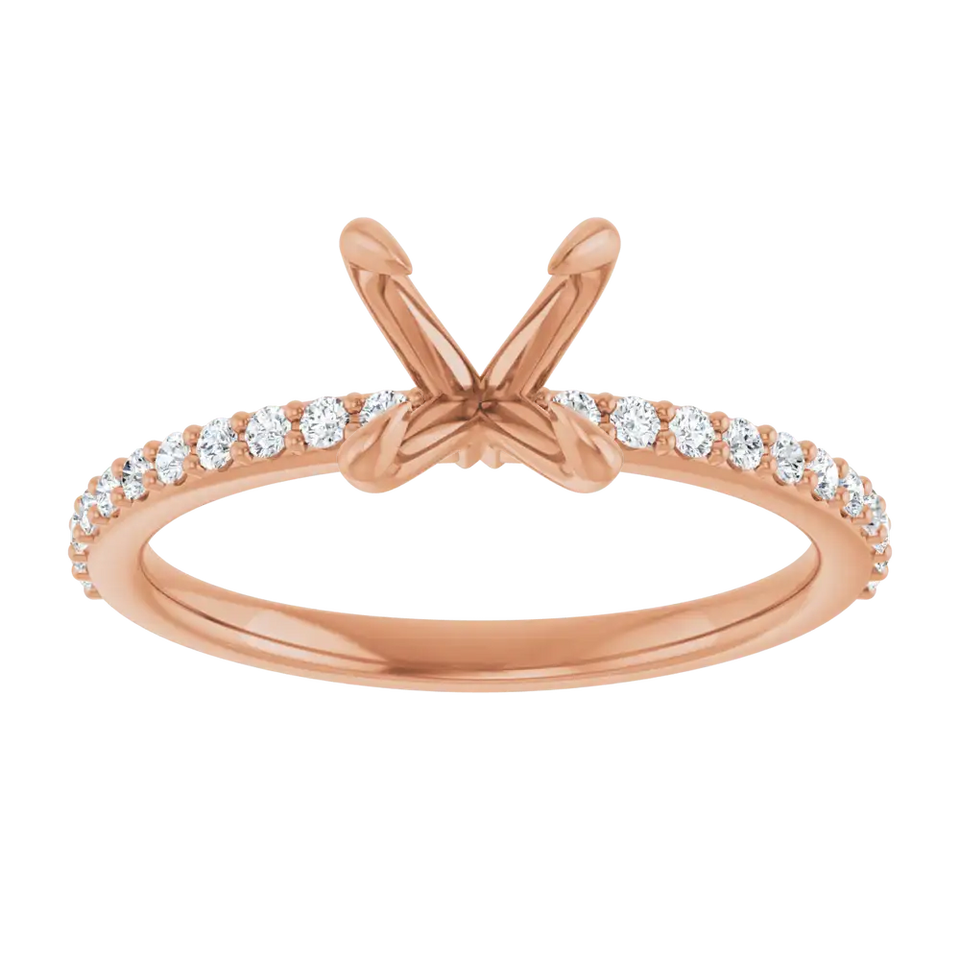 Rose gold engagement ring setting with diamond accents along the band and empty prongs at top for round stone.
