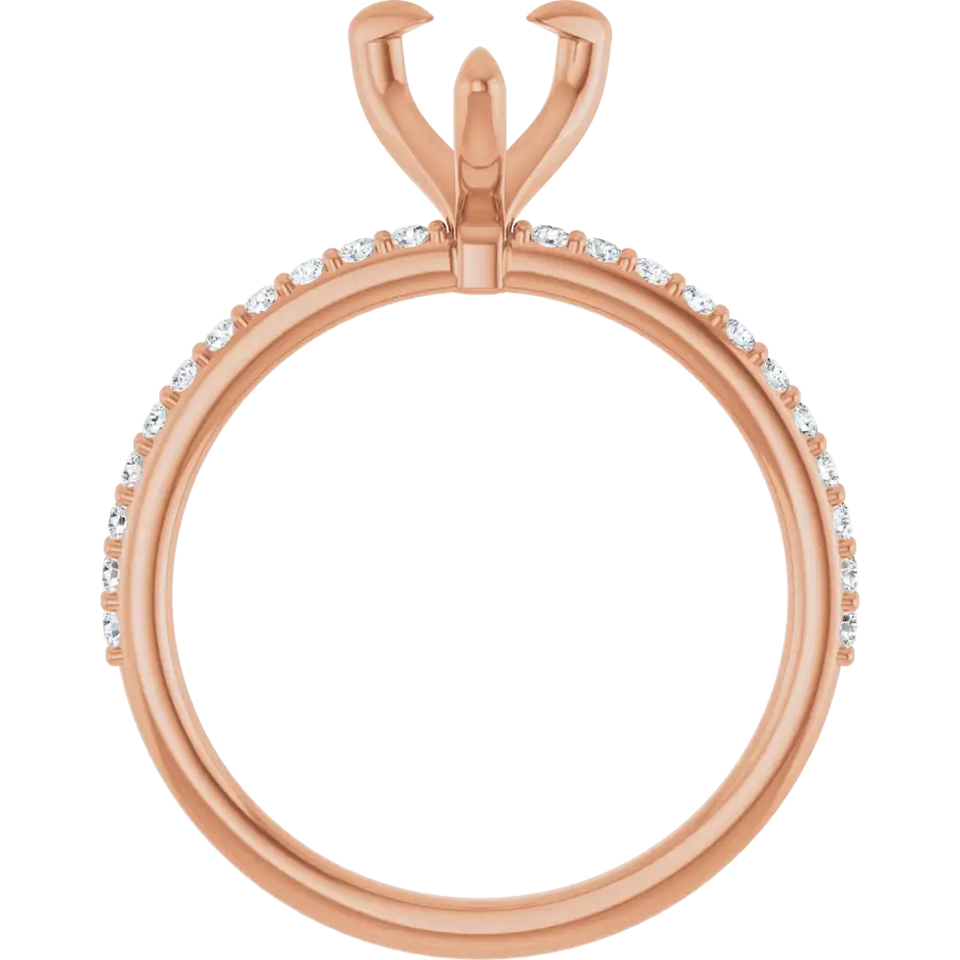 Rose gold engagement ring setting with pear-shaped stone holder and small diamonds set along the band.