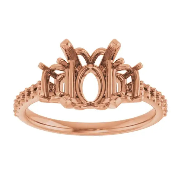 Rose gold engagement ring setting with oval stone center, decorative split shoulders, and textured band.