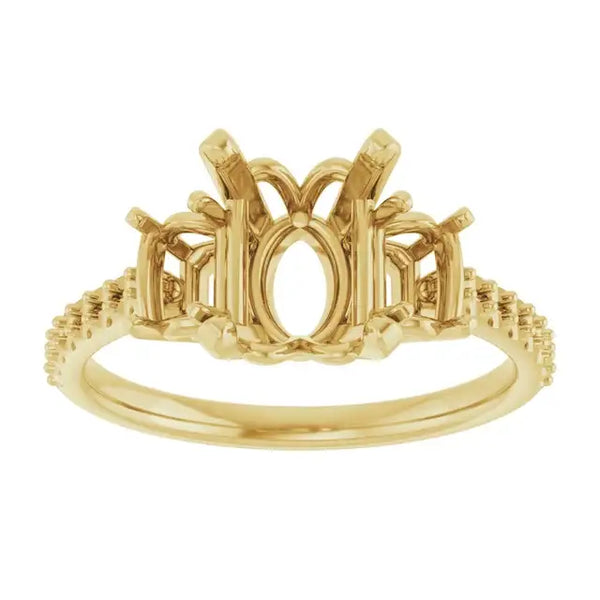 Gold engagement ring setting with oval stone center, decorative side details, and textured band.