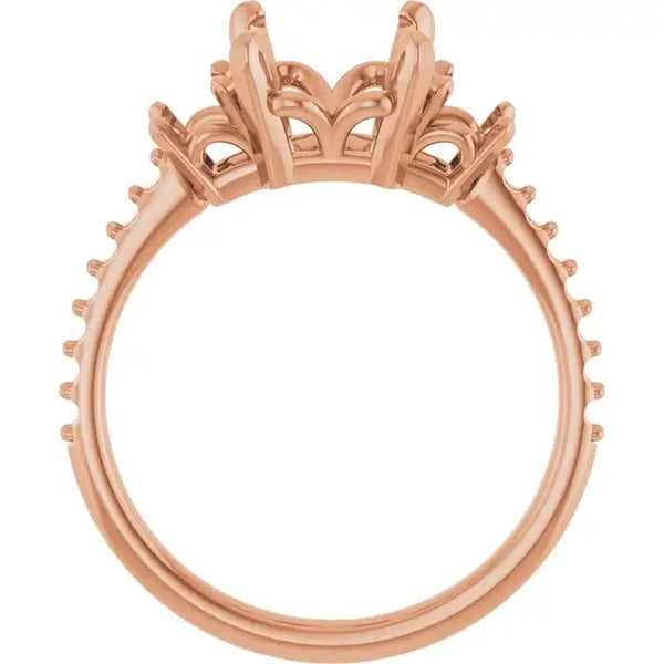 Rose gold engagement ring setting with ornate crown-style head and studded band, designed for emerald stone placement.