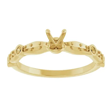 Gold engagement ring setting with V-shaped center stone holder and small accent stones along the band.
