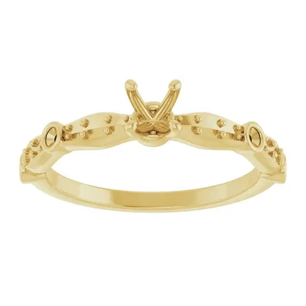 Gold engagement ring setting with V-shaped center stone holder and small accent stones along the band.