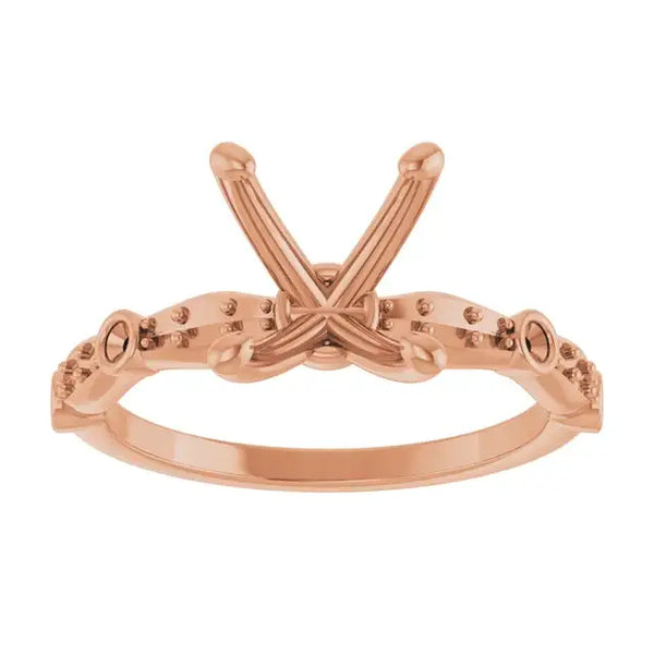 Rose gold engagement ring setting with oval stone holder and decorative side accents.