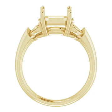 Yellow gold engagement ring setting with emerald-cut stone holder and two small diamond accents on shoulders.