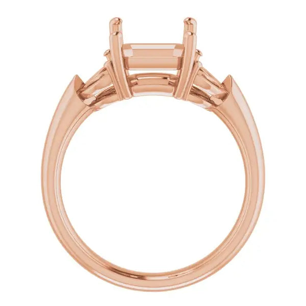Rose gold engagement ring setting with open emerald-cut stone holder and triangular side accents.
