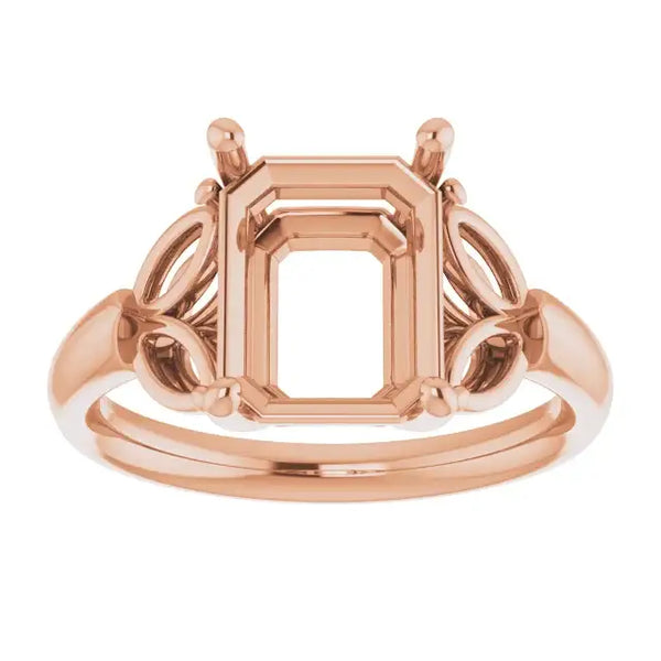 Rose gold engagement ring setting with emerald-cut center stone holder and decorative side details.