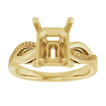Gold engagement ring setting with emerald-cut stone holder and textured twisted band design.