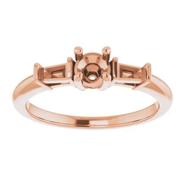 Rose gold engagement ring setting with round stone holder and rectangular side accents.