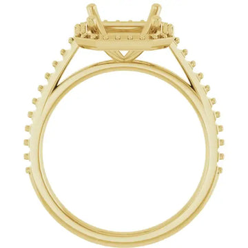 Gold-toned engagement ring setting with four-prong halo and pavé-set stones on band, viewed from side.