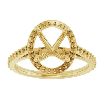 Gold engagement ring setting with oval halo and pavé band, four-prong design.
