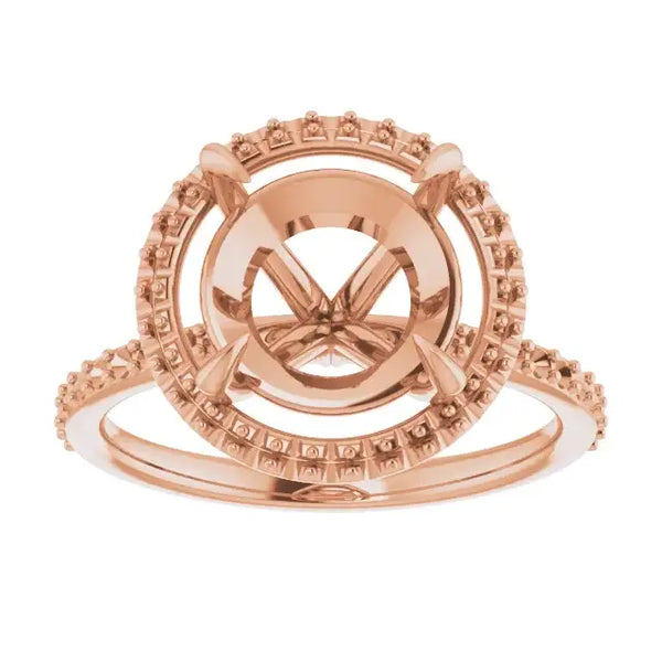 Rose gold halo engagement ring setting with round stone seat and pave-set accent stones on band.