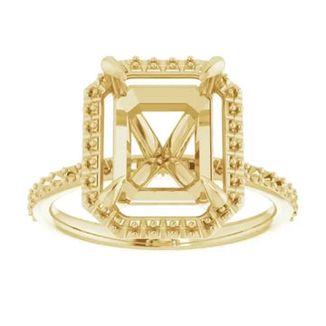 Gold engagement ring setting with halo and side stones in emerald-cut design, shown from front view.