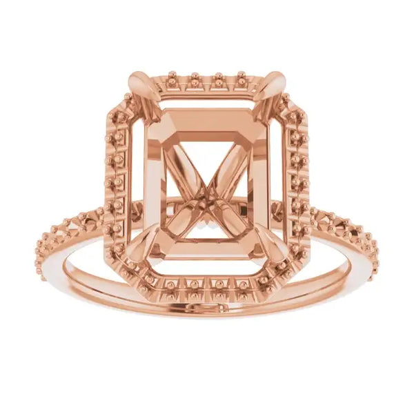 Rose gold halo engagement ring setting with emerald-cut stone mounting and decorative side accents.
