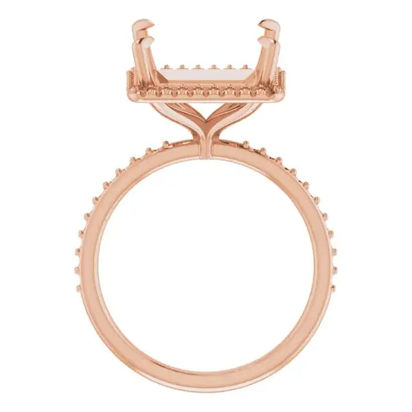Rose gold engagement ring setting with square stone holder and halo diamond accent band.