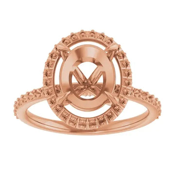 Rose gold halo engagement ring setting with oval stone center and textured accent stones on band.