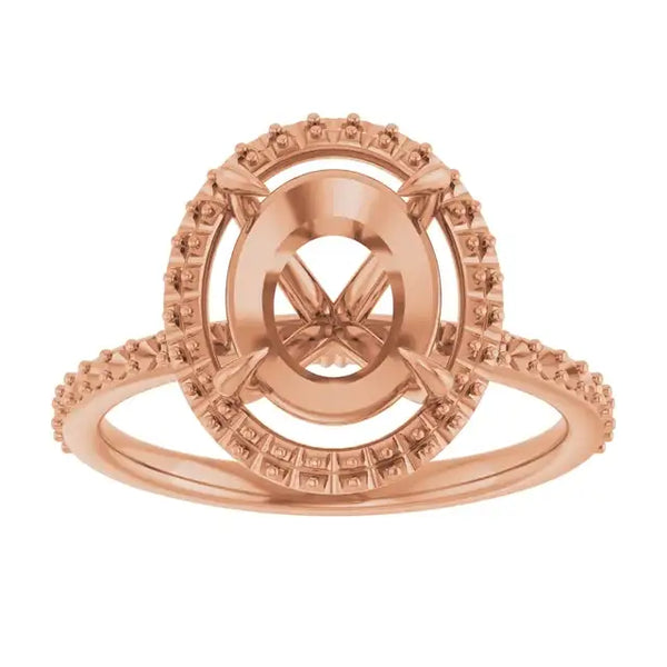 Rose gold halo engagement ring setting with oval stone center and textured accent stones on band.