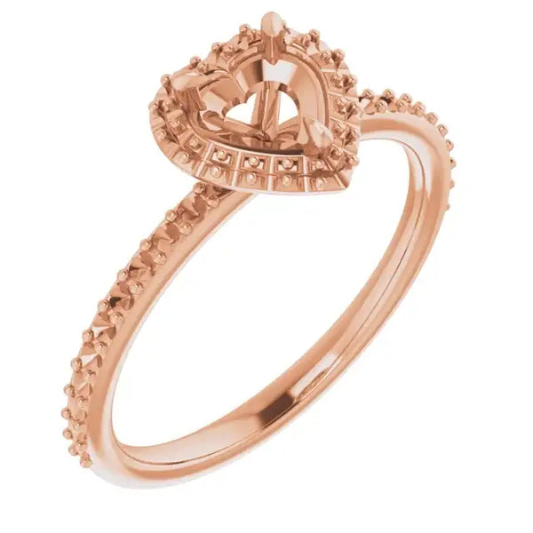 Rose gold engagement ring setting with decorative halo frame and textured band for heart-shaped stones.