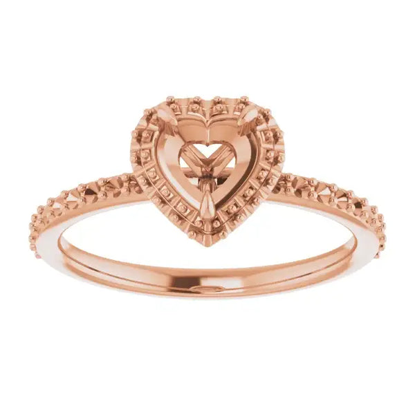 Rose gold engagement ring setting with heart-shaped halo center and decorative band.