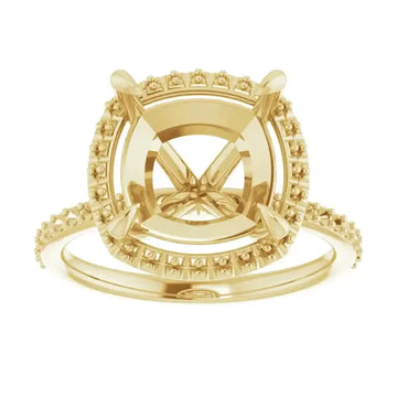 Gold halo engagement ring setting with cushion-cut stone center and diamond-accented band.