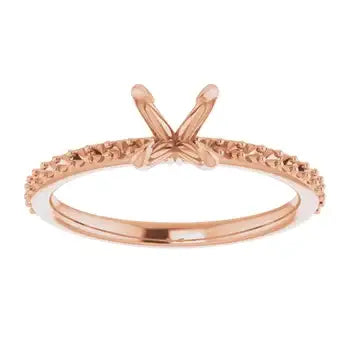 Rose gold engagement ring setting with diamond-studded band and V-shaped prongs for round stone.
