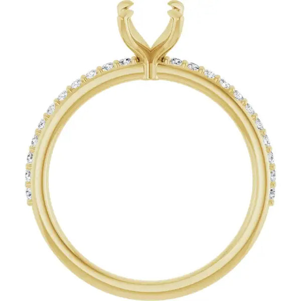Yellow gold engagement ring setting with diamond accents along the band and split prong head for emerald stone.
