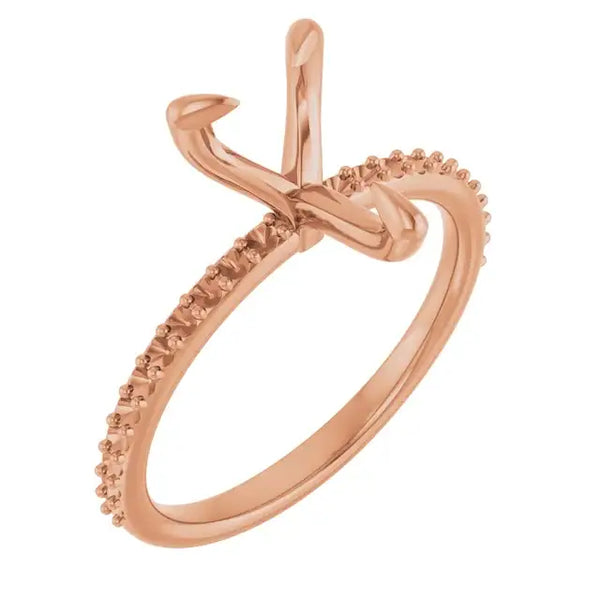 Rose gold engagement ring setting with curved prongs for pear-shaped stone and diamond-accented band.