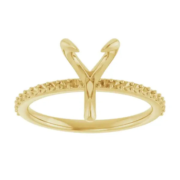 Gold engagement ring setting with V-shaped prongs for pear-shaped stones and textured band.