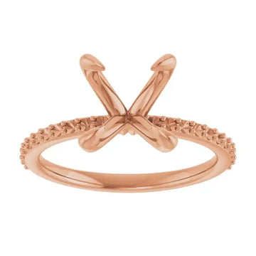 Rose gold engagement ring setting with crossed prongs and textured band for oval stone placement.