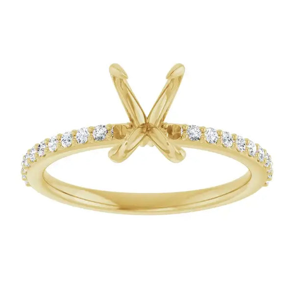 Gold engagement ring setting with X-shaped prongs and diamond-studded band for emerald stone.