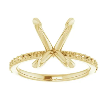 Gold engagement ring setting with X-shaped prongs and textured band for emerald stone placement.