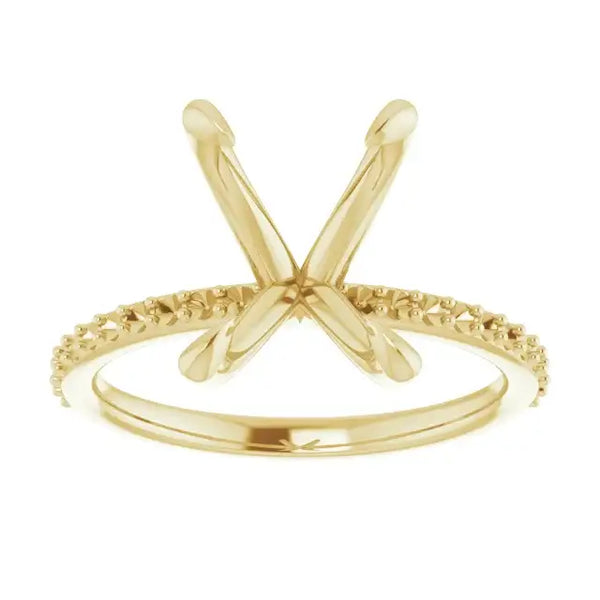 Gold engagement ring setting with X-shaped prongs and textured band for emerald stone placement.