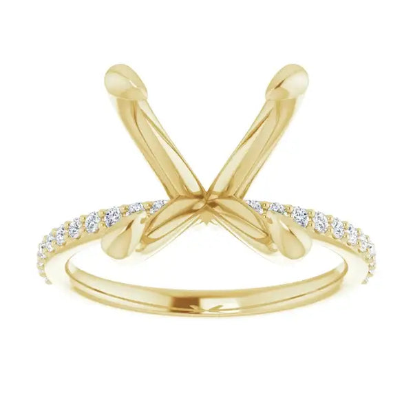 Gold engagement ring setting with crossed prongs and diamond-accented band, designed for cushion cut stones.