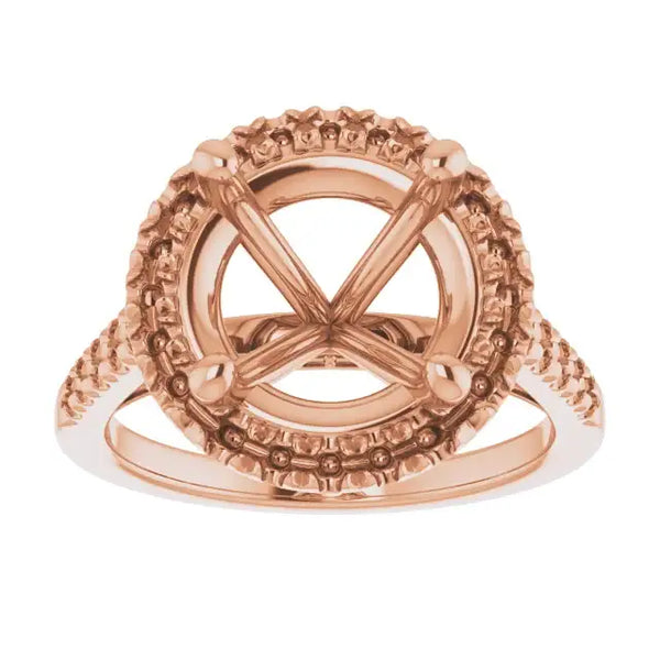Rose gold ring setting with ornate halo and accented band for round stone.