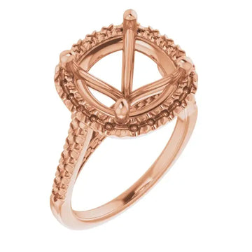 Rose gold ring with ornate halo setting and textured band designed for cushion-cut stones.