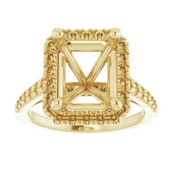 Gold ring setting with ornate square frame and X-pattern center, accented shoulders, designed for emerald stones.