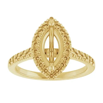Gold ring with marquise-shaped setting surrounded by textured beaded halo and split shank band.