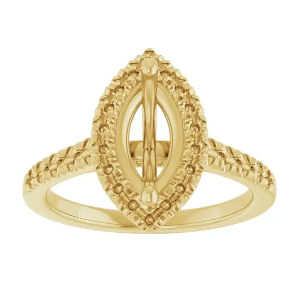 Gold ring with marquise-shaped setting surrounded by textured beaded halo and split shank band.