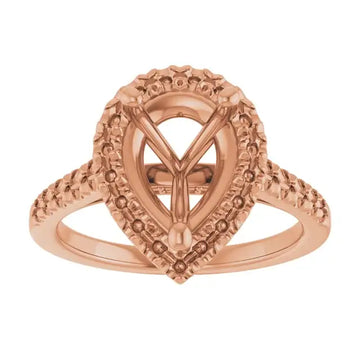 Rose gold engagement ring setting with ornate pear-shaped stone mount and textured band details.