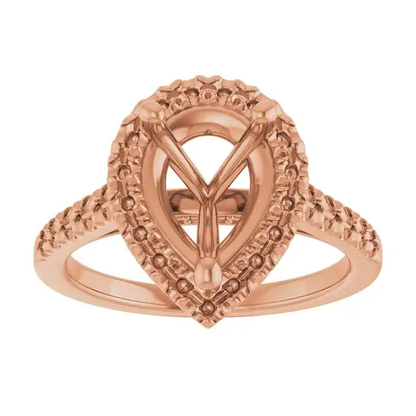 Rose gold engagement ring setting with ornate pear-shaped stone mount and textured band details.