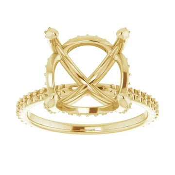 Gold engagement ring setting with crossed prongs and small diamonds around the band and halo.
