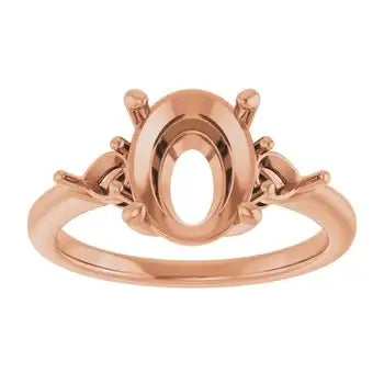 Rose gold engagement ring setting with oval stone mount and decorative shoulder details.