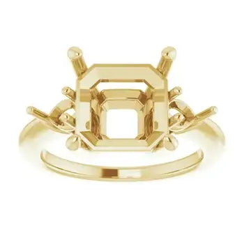 Gold engagement ring setting with four-prong asscher-cut stone mount and decorative side accents.