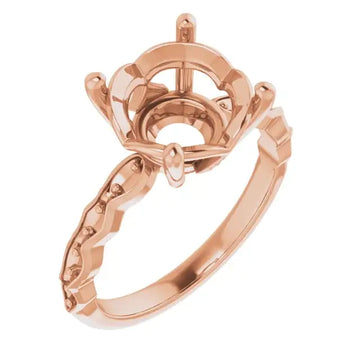 Rose gold engagement ring setting with ornate crown-style head and decorative band for round stone placement.