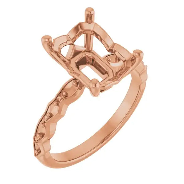 Rose gold engagement ring setting with ornate band and emerald-cut stone holder.